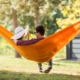 Couple relaxant dans un hamac orange au jardin.