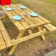 Table de pique-nique en bois avec vaisselle bleue.