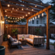 Terrasse en bois avec guirlandes lumineuses le soir.