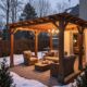 Pergola en bois avec mobilier de jardin enneigé.