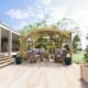 Terrasse jardin avec pergola et salon extérieur.