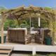 Pergola en bois avec fauteuils et plantes grimpantes.